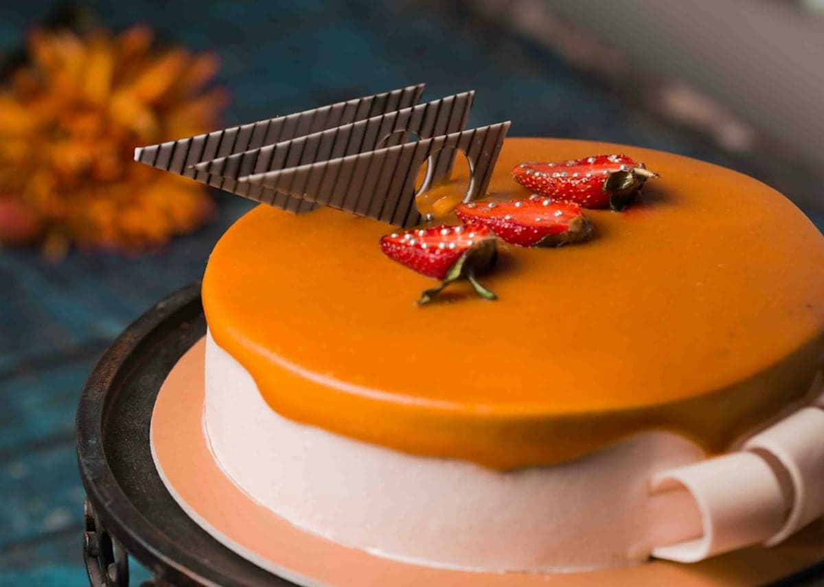 Torta con cubierta de naranja, fresas y láminas de chocolate